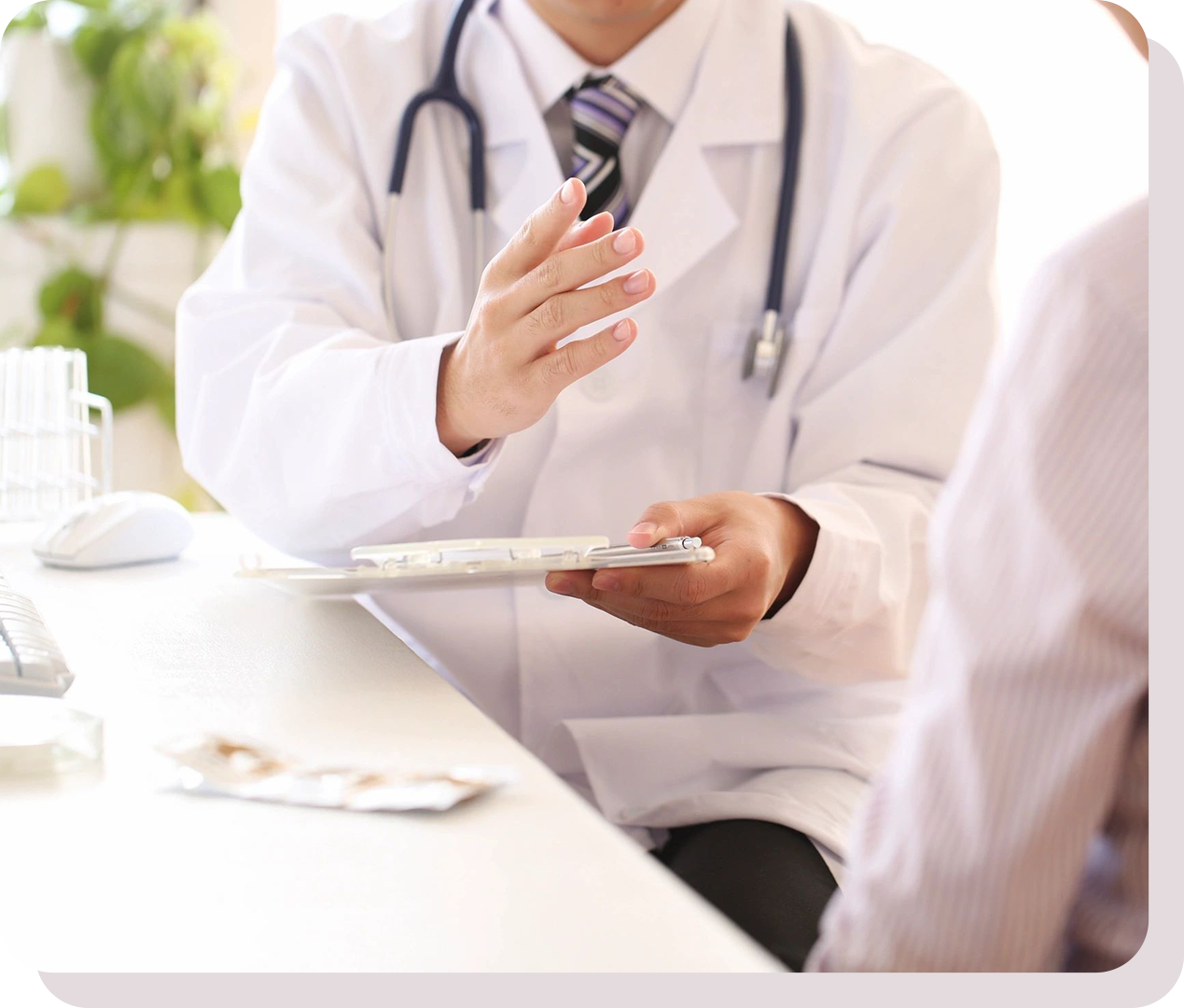 A doctor in a white coat with a stethoscope discusses a clipboard with a patient in an office setting.