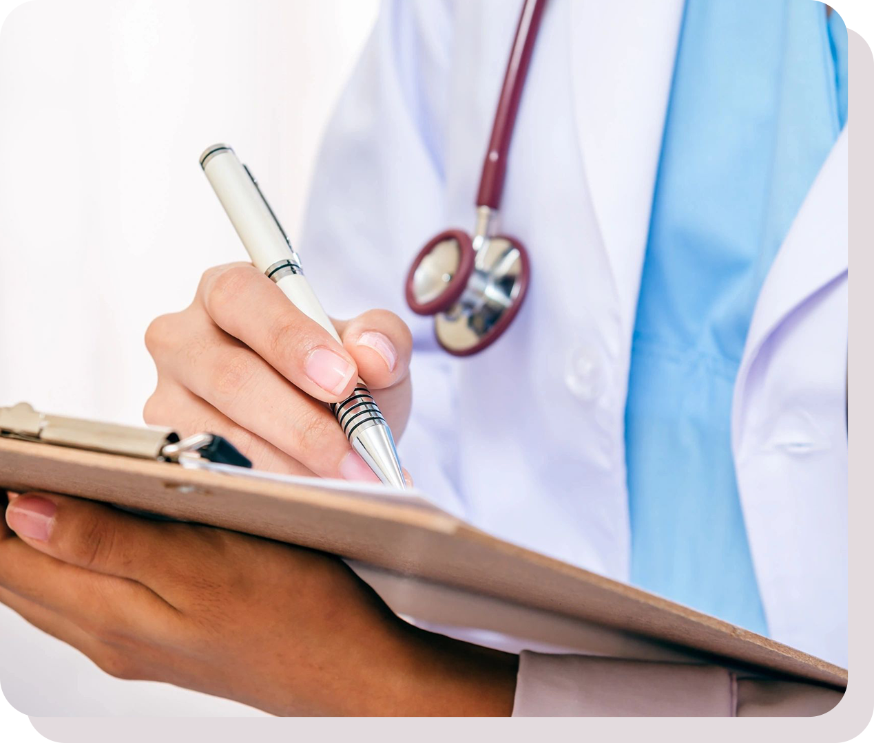 A person wearing a white coat and stethoscope writes on a clipboard with a pen.