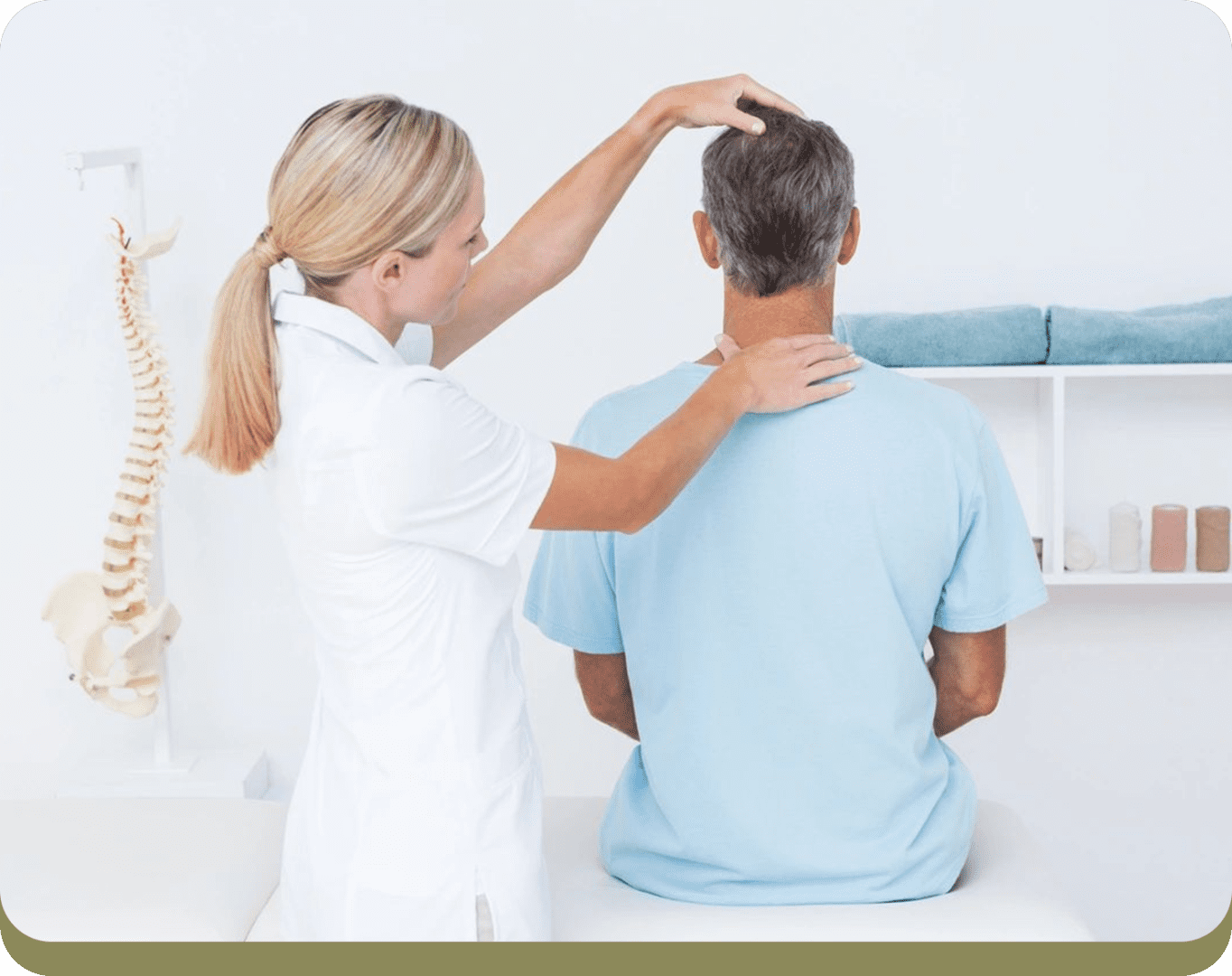 A healthcare professional in a white uniform examines a seated man by touching his head and neck. A model of a spine and some folded towels are visible in the background.