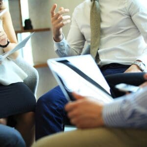 A group of people sitting around each other.